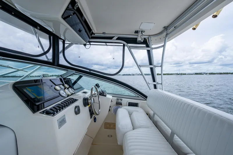 Slide: The Image of 2002 Sport-Craft 3150 Sportfish boat interior with steering wheel and navigation system. - 25