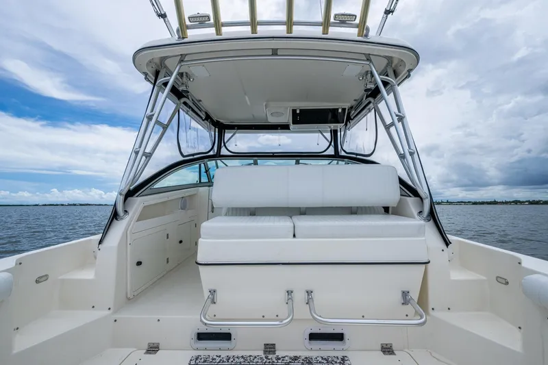 Slide: The Image of 2002 Sport-Craft 3150 Sportfish boat interior with seating, ocean view, and cloudy sky. - 27