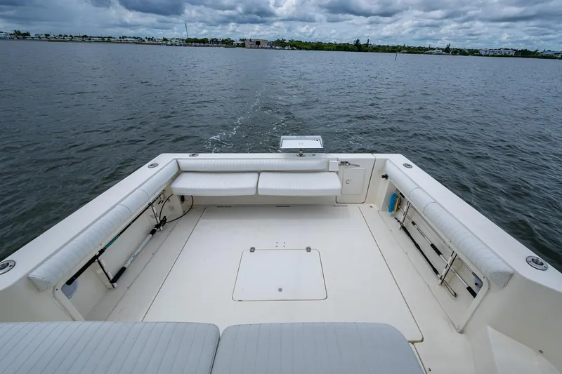 Slide: The Image of 2002 Sport-Craft 3150 Sportfish boat deck with seating, on calm waters under cloudy skies. - 28