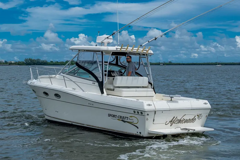 Slide: The Image of 2002 Sport-Craft 3150 Sportfish boat on water, clear sky, person onboard. - 5