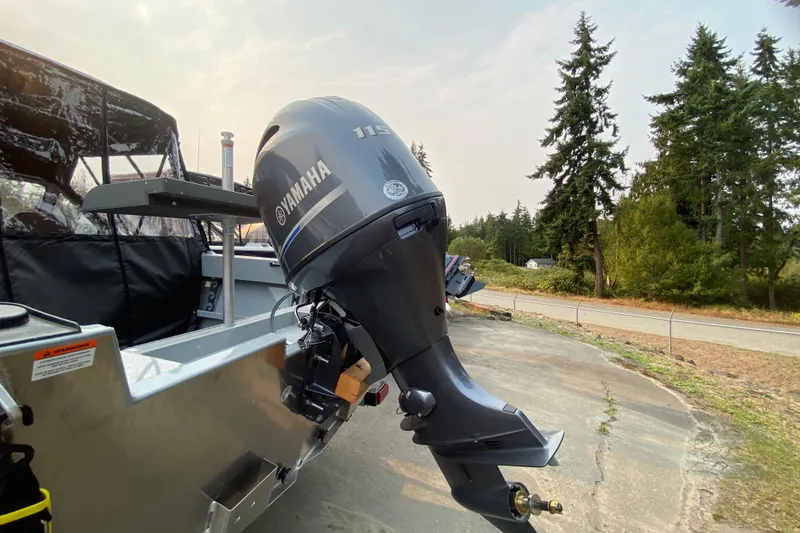 Slide: The Image of 2026 Hewescraft 180 Sportsman with Yamaha 115 outboard motor, parked outdoors. - 4