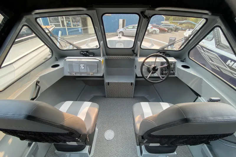 Slide: The Image of Interior of 2026 Hewescraft 180 Sportsman boat, featuring dual seats and steering console. - 9