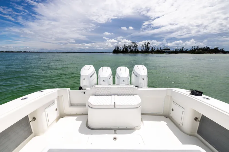 Slide: The Image of 2009 Yellowfin 42 Offshore boat with four engines on calm water under a cloudy sky. - 27