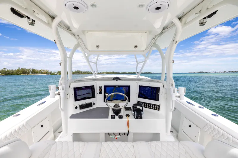 Slide: The Image of 2009 Yellowfin 42 Offshore boat helm with navigation screens, steering wheel, and ocean view. - 33