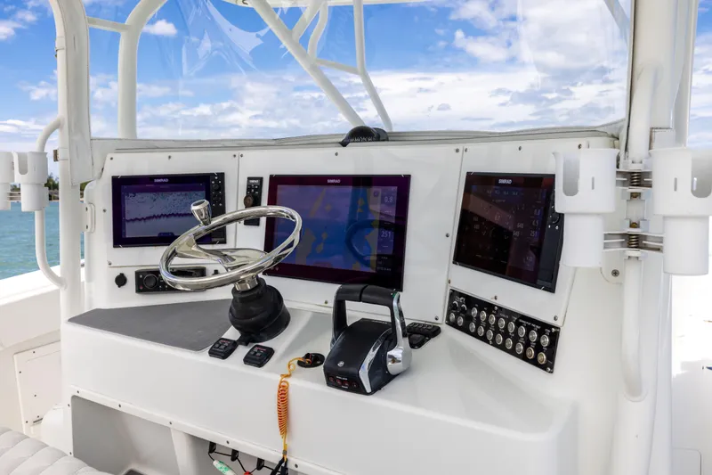 Slide: The Image of 2009 Yellowfin 42 Offshore boat dashboard with navigation screens and steering wheel. - 35