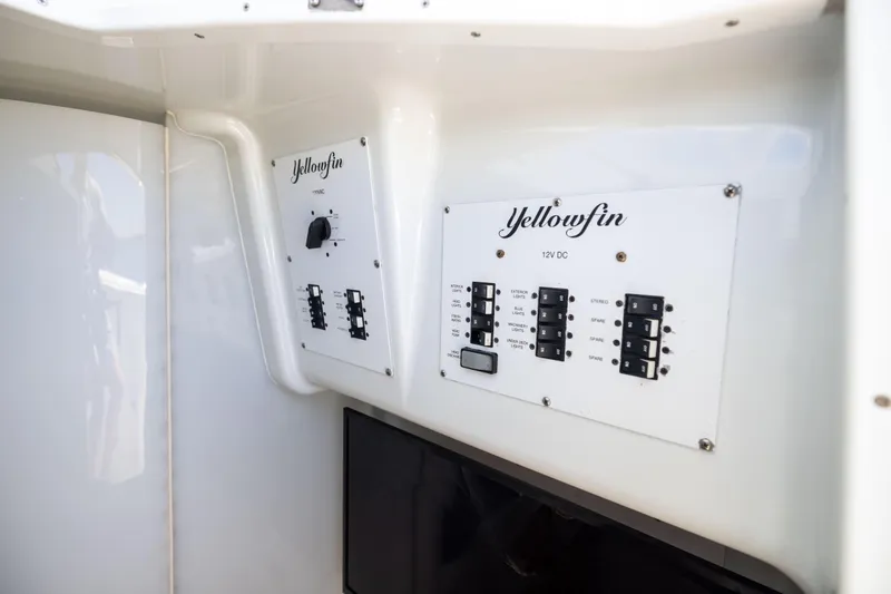 Slide: The Image of Control panel of a 2009 Yellowfin 42 Offshore boat, featuring switches and labels. - 52