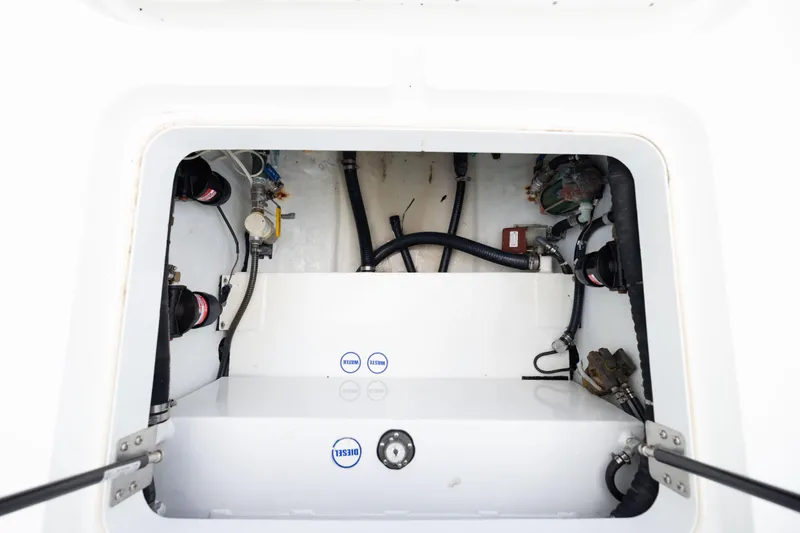Slide: The Image of 2009 Yellowfin 42 Offshore boat compartment with visible hoses and mechanical components. - 57
