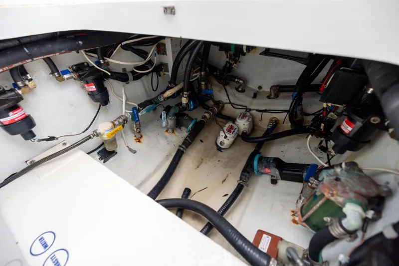 Slide: The Image of Engine compartment of 2009 Yellowfin 42 Offshore boat, showcasing various mechanical components and wiring. - 58