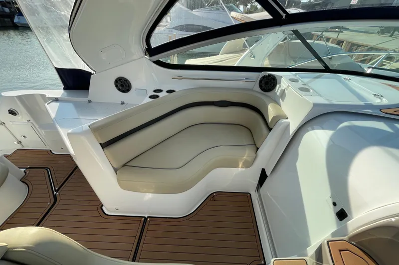 Slide: The Image of 2019 Rinker 370 EX boat interior with beige seating and modern dashboard. - 13
