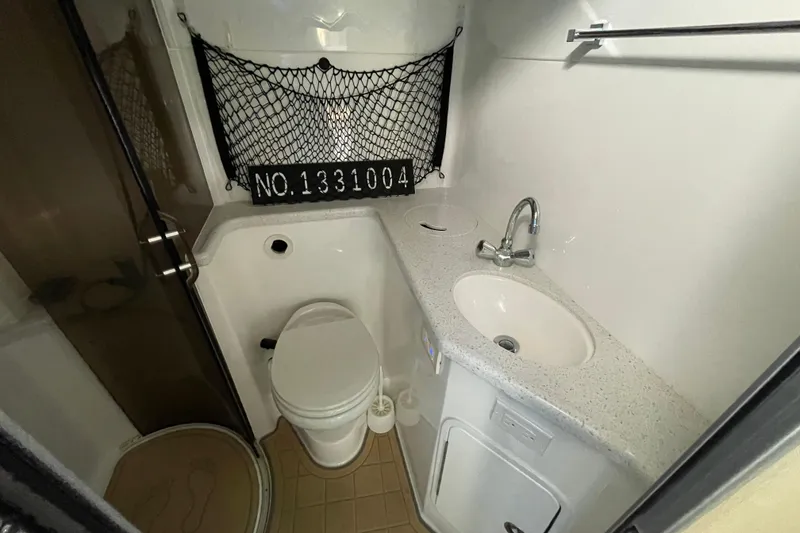 Slide: The Image of White sofa in 2019 Rinker 370 EX cabin with wooden cabinets and curtains. - 21