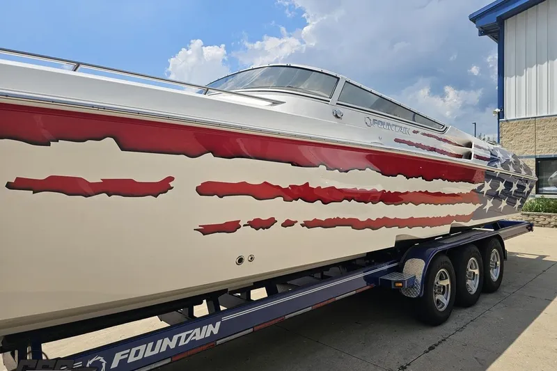 Slide: The Image of 2007 Fountain 42 Lightning boat with American flag design on trailer, under a blue sky. - 21