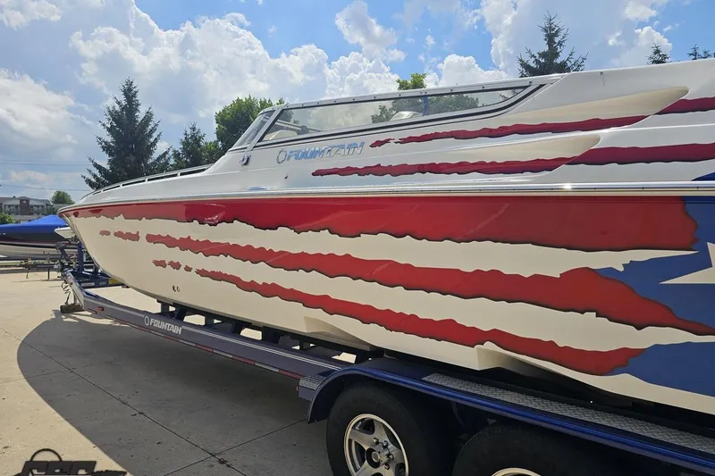 Slide: The Image of 2007 Fountain 42 Lightning boat with patriotic design on trailer under blue sky. - 23