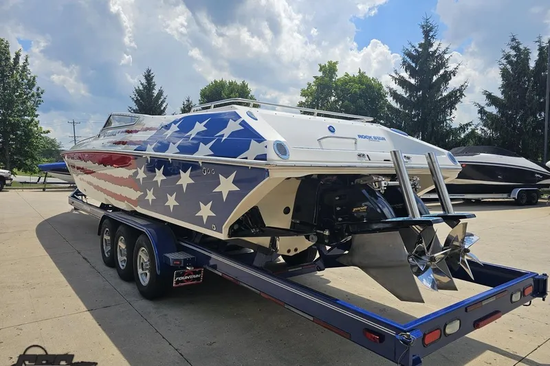 Slide: The Image of 2007 Fountain 42 Lightning boat with American flag design on trailer, under a cloudy sky. - 26