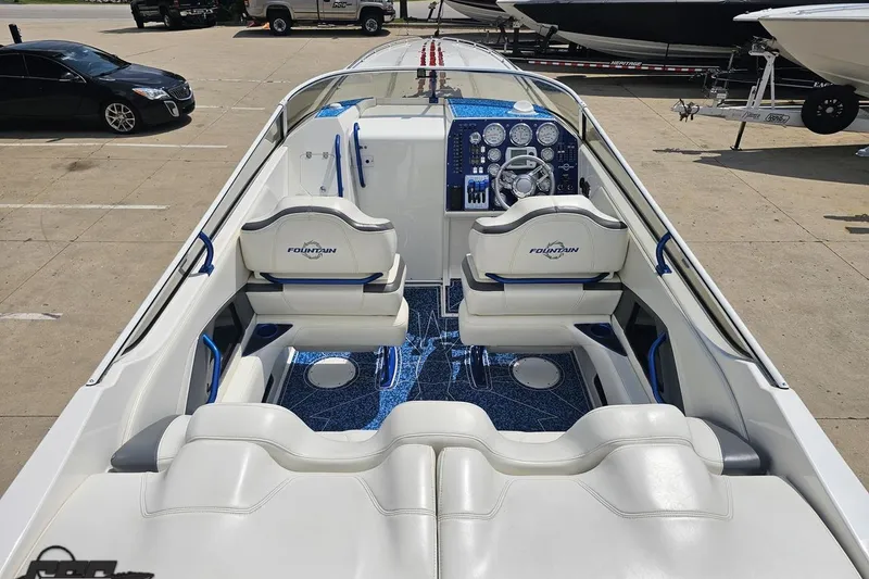 Slide: The Image of 2007 Fountain 42 Lightning boat interior with white seating and blue accents, parked in a lot. - 40