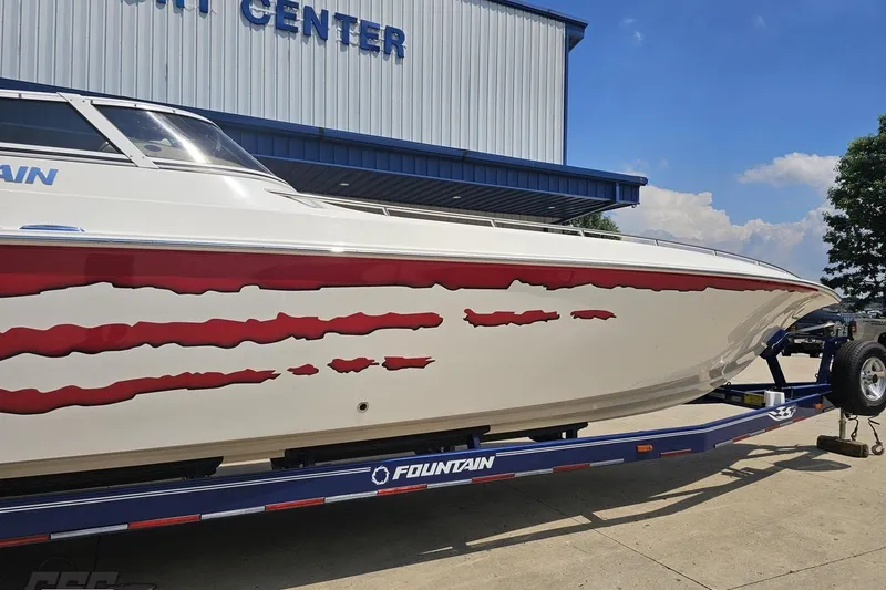 Slide: The Image of 2007 Fountain 42 Lightning boat with red graphics on trailer, outside a marine center. - 5