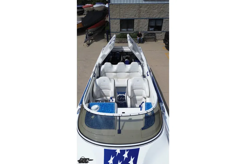 Slide: The Image of 2007 Fountain 42 Lightning speedboat with white seating and blue accents, docked outdoors. - 67