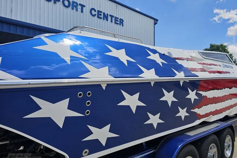 Slide: The Image of 2007 Fountain 42 Lightning boat with American flag design, parked at a sport center. - 7