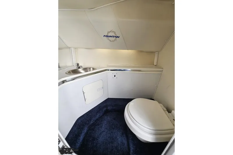Slide: The Image of 2007 Fountain 42 Lightning boat interior with sink and toilet, featuring blue carpet. - 78