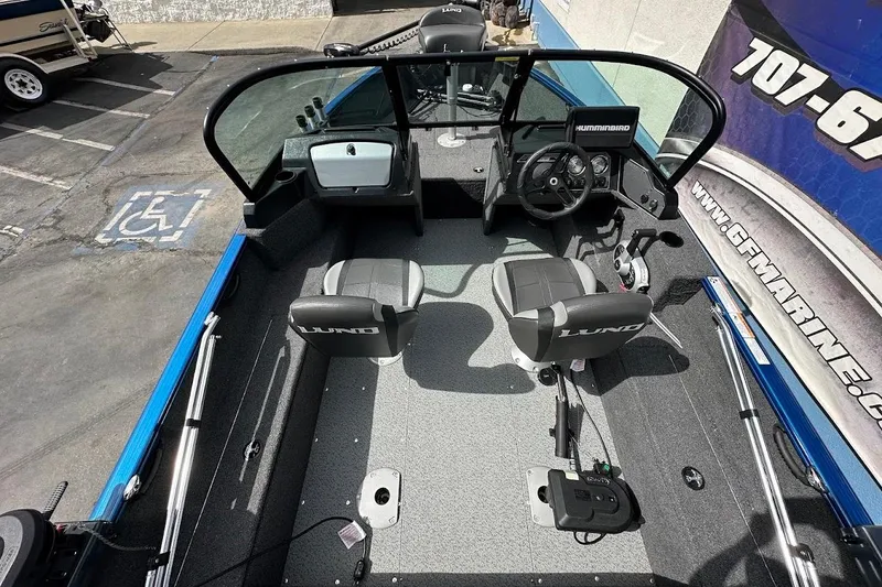 Slide: The Image of 2024 Lund 1650 Rebel XL Sport boat interior with steering console and seating. - 11