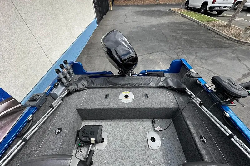 Slide: The Image of 2024 Lund 1650 Rebel XL Sport boat interior with motor and fishing rod holders. - 14