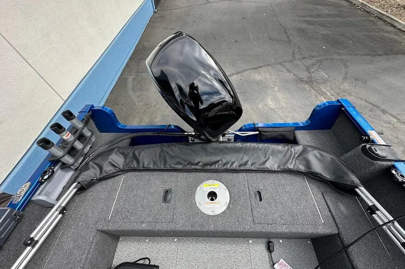 Slide: The Image of 2024 Lund 1650 Rebel XL Sport boat interior with motor and rod holders. - 16