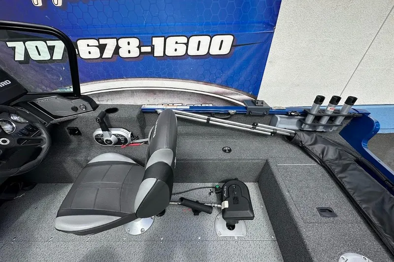 Slide: The Image of 2024 Lund 1650 Rebel XL Sport boat interior with steering wheel and seating. - 17