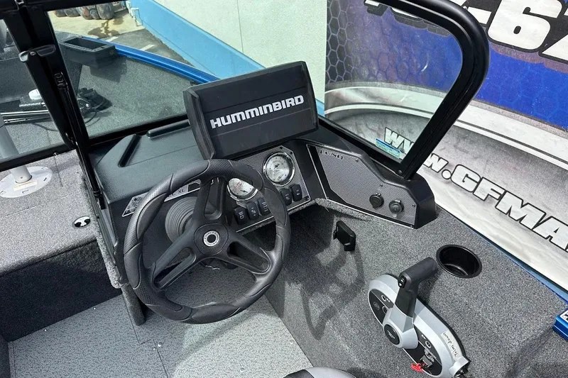 Slide: The Image of 2024 Lund 1650 Rebel XL Sport boat dashboard with steering wheel and Humminbird display. - 19