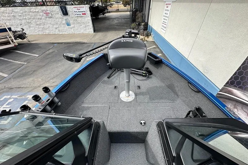 Slide: The Image of 2024 Lund 1650 Rebel XL Sport boat interior with trolling motor and seating. - 23