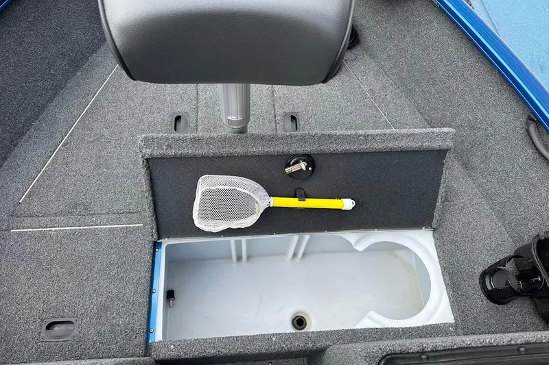 Slide: The Image of 2024 Lund 1650 Rebel XL Sport boat interior with storage compartment and fishing net. - 30