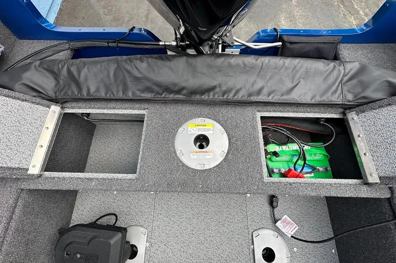 Slide: The Image of 2024 Lund 1650 Rebel XL Sport boat interior with storage compartments and battery. - 33
