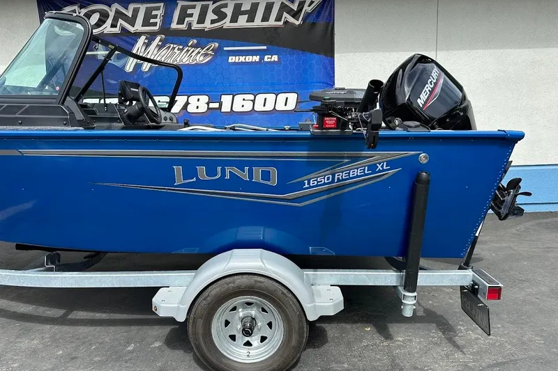 Slide: The Image of 2024 Lund 1650 Rebel XL Sport boat on trailer, blue exterior, Mercury engine. - 7