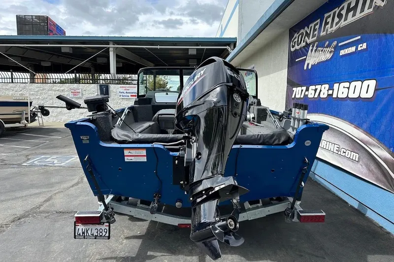Slide: The Image of 2024 Lund 1650 Rebel XL Sport boat with Mercury outboard motor, parked at dealership. - 9
