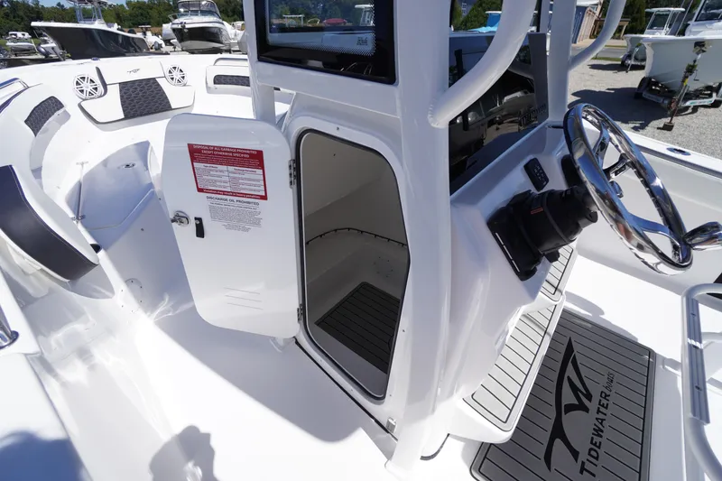 Slide: The Image of 2026 Tidewater 220 CC Adventure boat interior with open console door and steering wheel. - 20