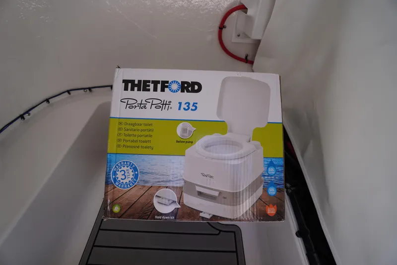 Slide: The Image of Portable toilet box inside 2026 Tidewater 220 CC Adventure boat cabin. - 22