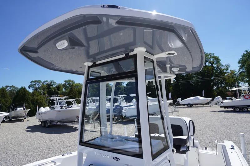 Slide: The Image of 2026 Tidewater 220 CC Adventure boat with T-top, displayed outdoors on a sunny day. - 23