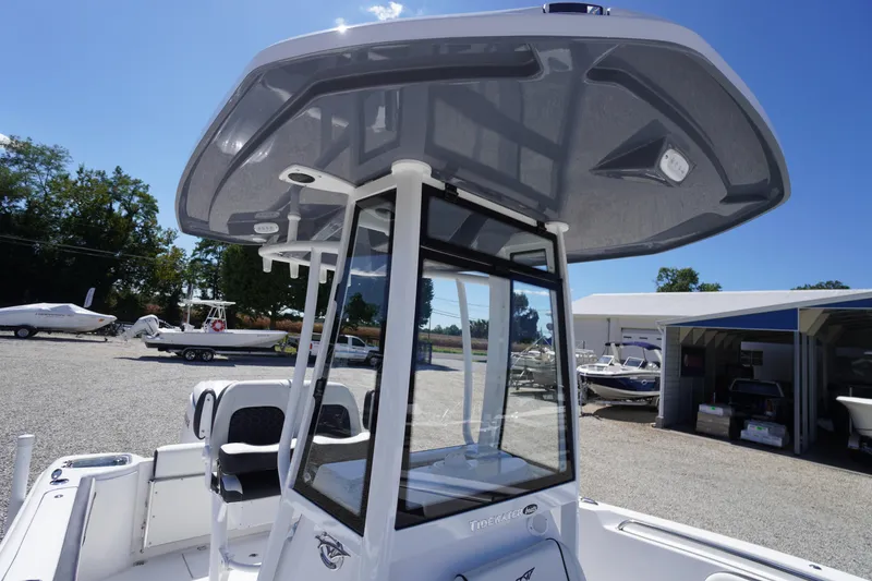 Slide: The Image of 2026 Tidewater 220 CC Adventure boat with T-top in a marina setting. - 24