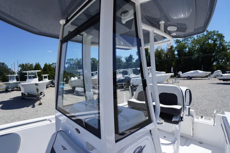 Slide: The Image of 2026 Tidewater 220 CC Adventure boat, featuring sleek design and modern console, in a boatyard. - 25