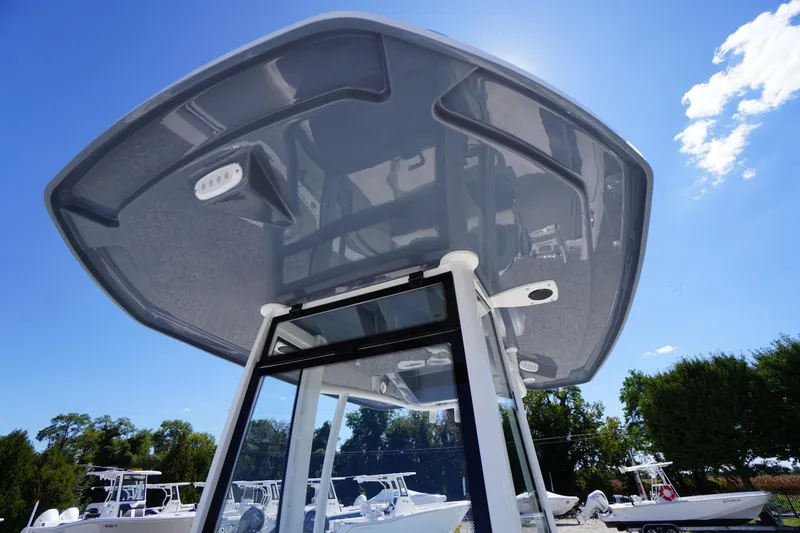 Slide: The Image of 2026 Tidewater 220 CC Adventure boat with sleek T-top design under clear blue sky. - 26