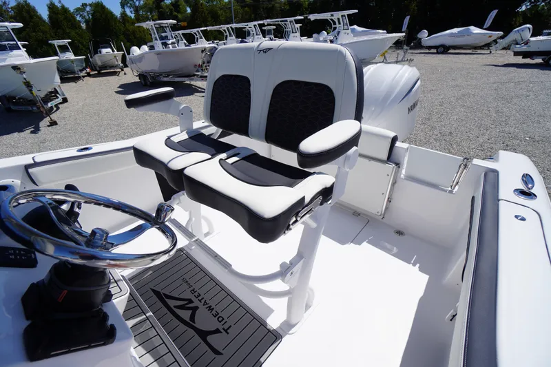 Slide: The Image of 2026 Tidewater 220 CC Adventure boat interior with dual seats and steering wheel. - 35