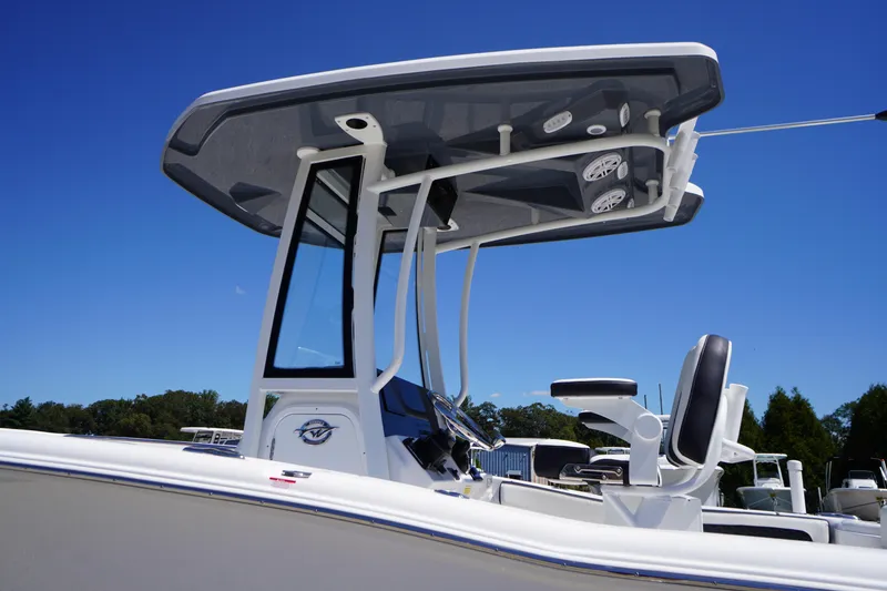 Slide: The Image of 2026 Tidewater 220 CC Adventure boat with T-top and seating, under clear blue sky. - 56