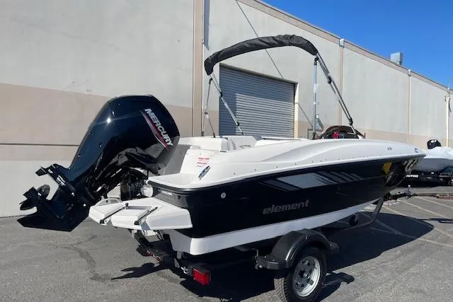 Slide: The Image of 2026 Bayliner Element E16 boat with Mercury outboard motor, parked on a trailer. - 0
