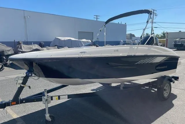 Slide: The Image of 2026 Bayliner Element E16 boat on trailer, parked outdoors. - 2