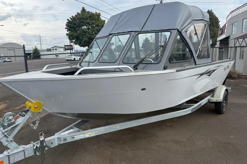 Slide: The Image of 2026 Fish Rite Sportsman 20 boat on trailer, parked outdoors with canopy. - 10