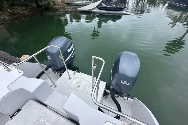 Slide: The Image of 2005 Glacier Bay 2680 Coastal Runner with twin Yamaha 150 engines docked on calm water. - 10