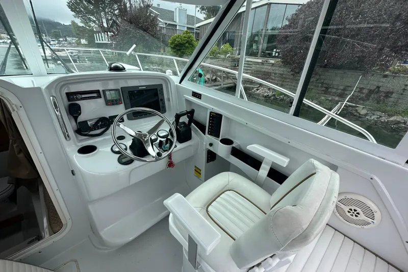 Slide: The Image of 2005 Glacier Bay 2680 Coastal Runner helm with steering wheel, controls, and navigation equipment. - 14