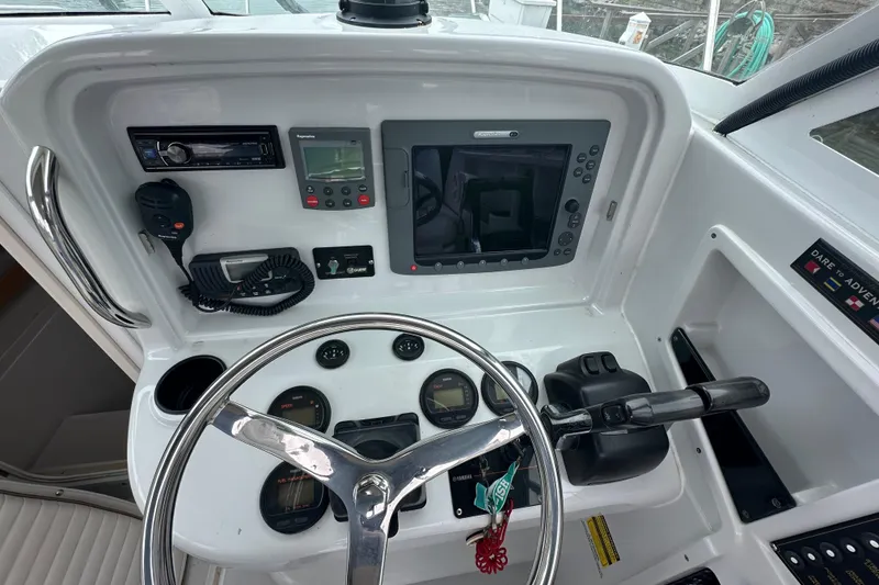 Slide: The Image of 2005 Glacier Bay 2680 Coastal Runner dashboard with steering wheel, gauges, and navigation equipment. - 16