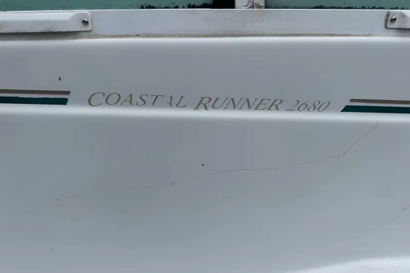 Slide: The Image of 2005 Glacier Bay 2680 Coastal Runner boat side view with model name. - 23