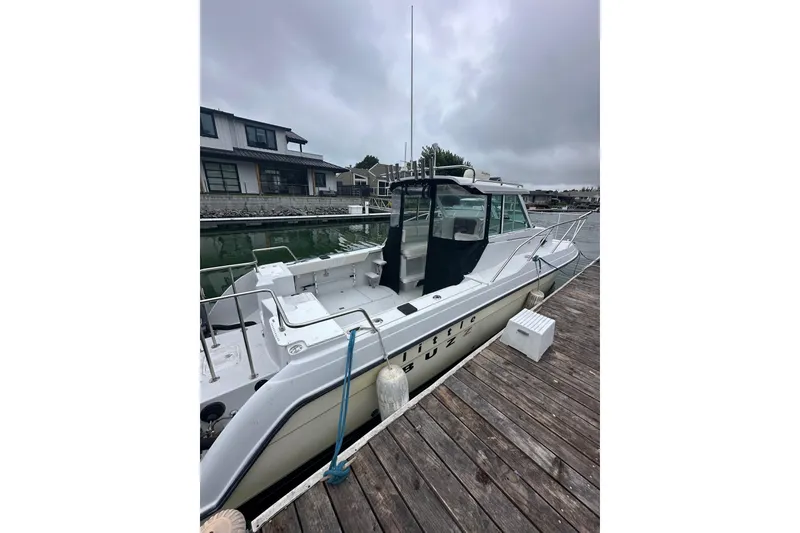 Slide: The Image of 2005 Glacier Bay 2680 Coastal Runner docked at a marina under cloudy skies. - 5