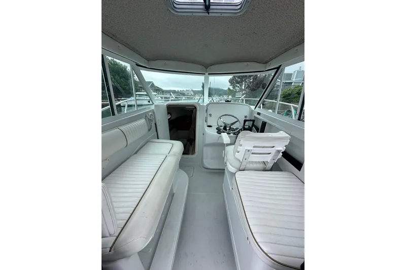 Slide: The Image of Interior of 2005 Glacier Bay 2680 Coastal Runner boat with white seating and steering area. - 7