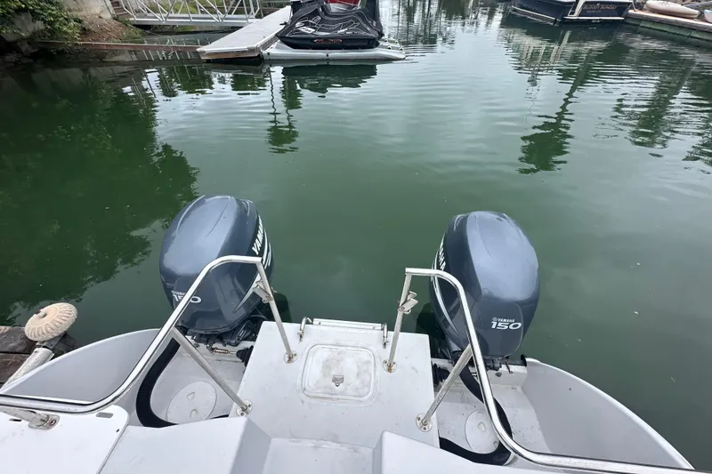 Slide: The Image of 2005 Glacier Bay 2680 Coastal Runner with twin Yamaha 150 engines docked in calm waters. - 9